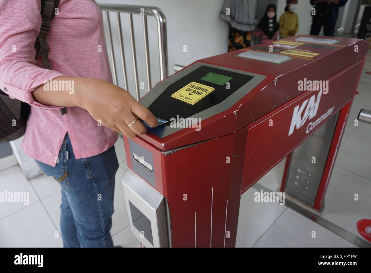 Solo, Indonesien - 16.. Juli 2022. Eine Frau strichen eine E-Money-Karte, um ein Ticket für die KRL-Pendlerlinie zu bezahlen, bevor sie den Bahnhof Solo Balapan betreten. Stockfoto
