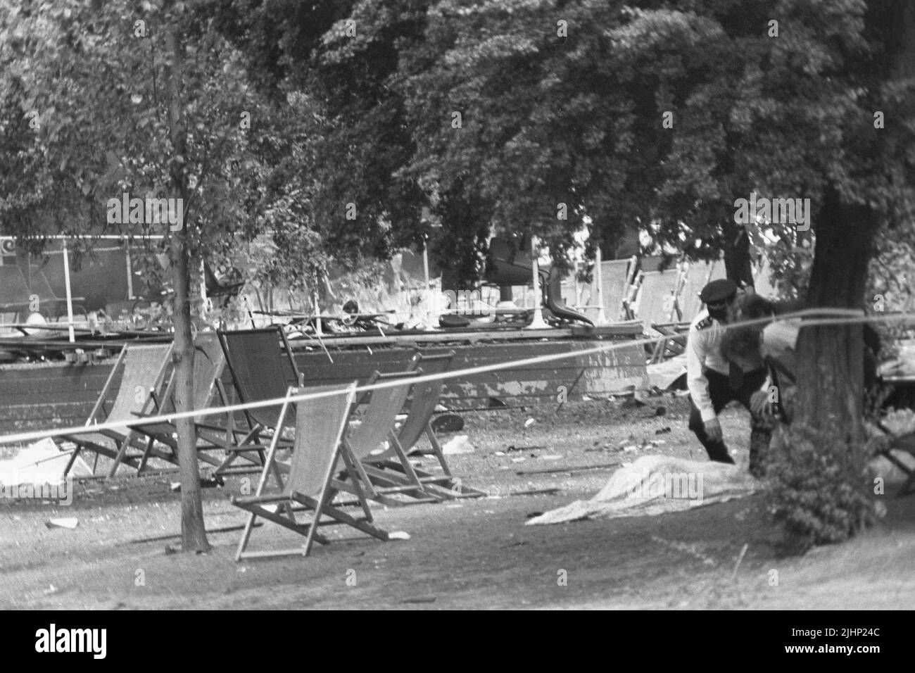 Aktenfoto vom 20/7/1982 von der Polizei, die nach einer Explosion einer IRA-Bombe eine von einer Decke bedeckte Leiche in der Nähe des verwüsteten Bandstandes im Regent's Park, London, untersucht. Die Familien der Soldaten, die im Hyde Park und im Regent's Park IRA-Bombenangriffe getötet wurden, haben erzählt, wie ihr Leiden 40 Jahre später ungebrochen bleibt. Bei den beiden Anschlägen, die sich am 20 1982. Juli in London innerhalb weniger Stunden ereigneten, starben insgesamt 11 Militärangehörige. Ausgabedatum: Mittwoch, 20. Juli 2022. Stockfoto Aktenfoto vom 20/7/1982 von der Polizei, die nach einer Explosion einer IRA-Bombe eine von einer Decke bedeckte Leiche in der Nähe des verwüsteten Bandstandes im Regent's Park, London, untersucht. Die Familien der Soldaten, die im Hyde Park und im Regent's Park IRA-Bombenangriffe getötet wurden, haben erzählt, wie ihr Leiden 40 Jahre später ungebrochen bleibt. Bei den beiden Anschlägen, die sich am 20 1982. Juli in London innerhalb weniger Stunden ereigneten, starben insgesamt 11 Militärangehörige. Ausgabedatum: Mittwoch, 20. Juli 2022. Stockfoto