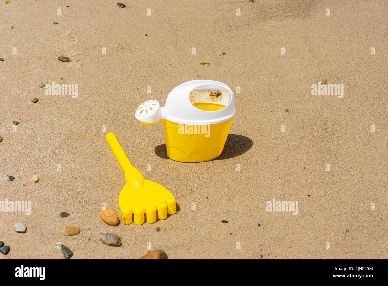 Nahaufnahme eines gelben Kinder Plastikspielzeug Schaufel am Strand. Stockfoto