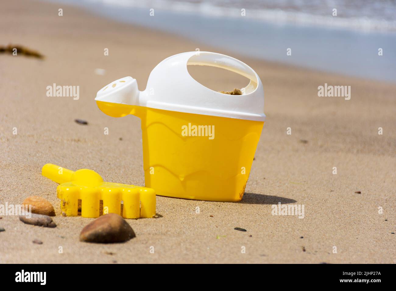 Nahaufnahme eines gelben Kinder Plastikspielzeug Schaufel am Strand. Stockfoto