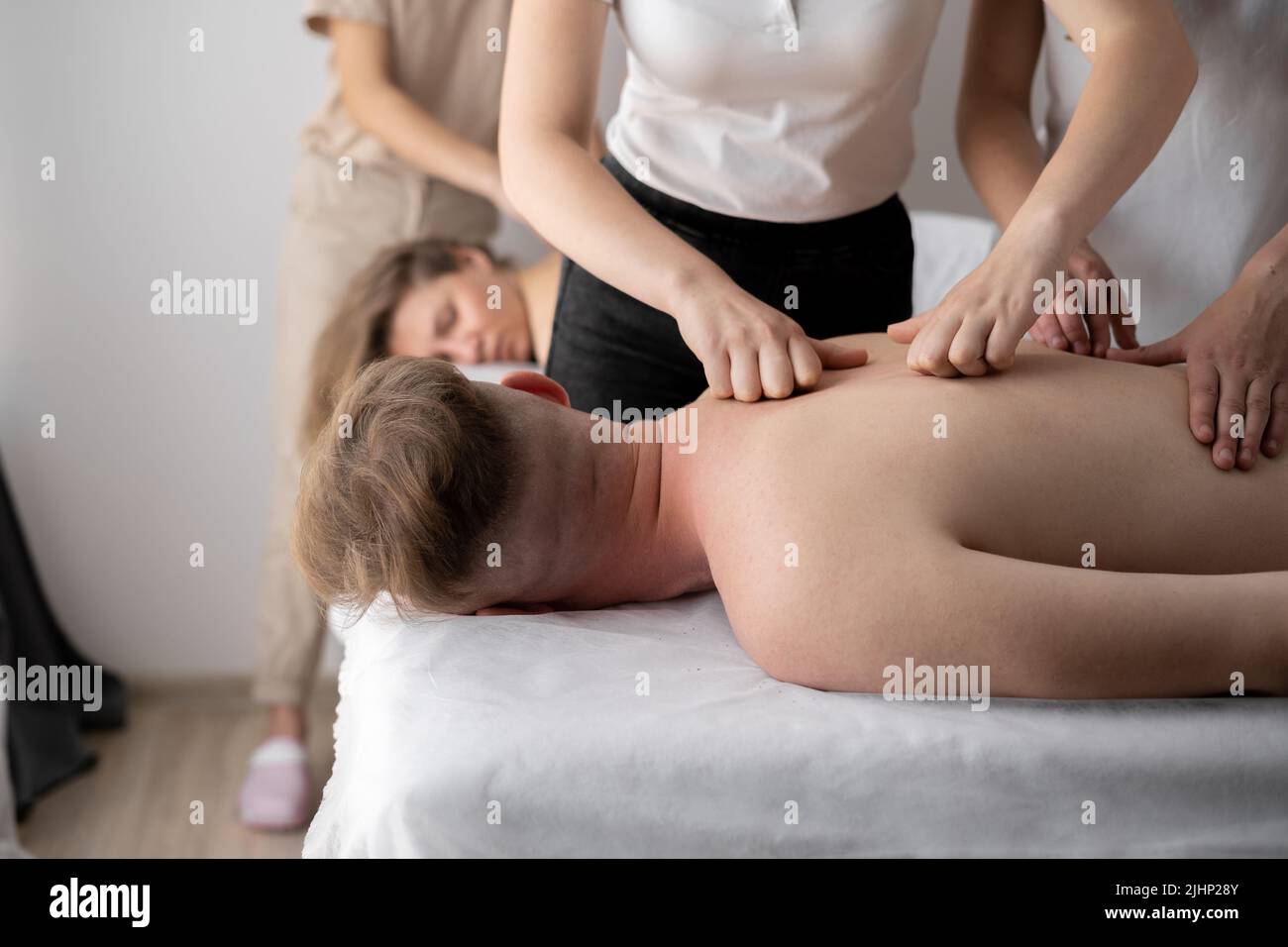 Massagetraining. Mann mit Massage im Spa-Salon, Nahaufnahme. Masseuse massiert Schultern eines männlichen Athleten, arbeiten mit Muskeln. Stockfoto