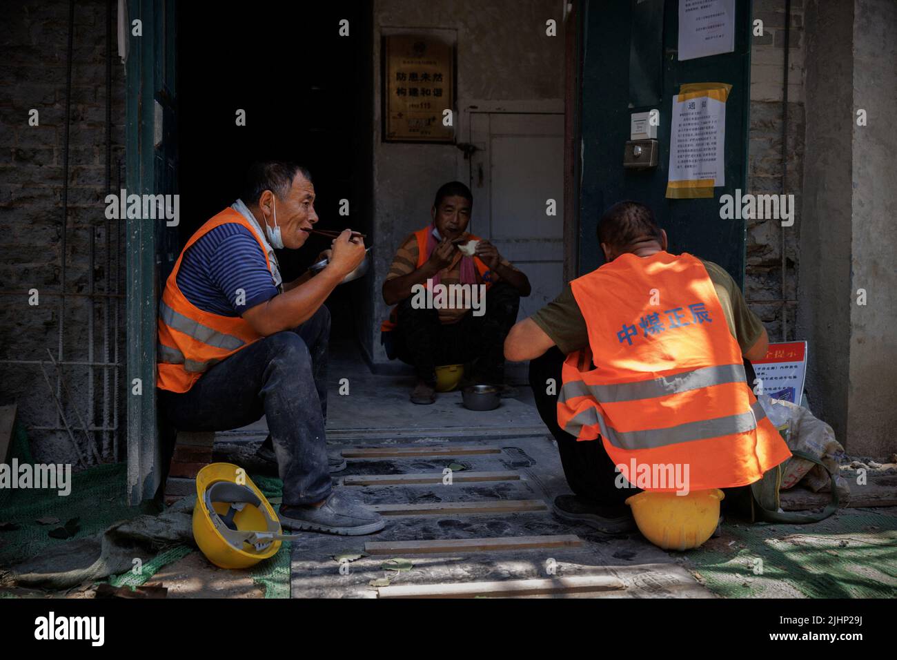 Arbeiter essen Mittagessen auf einer Baustelle in Peking, China, 20. Juli 2022. REUTERS/Thomas Peter Stockfoto