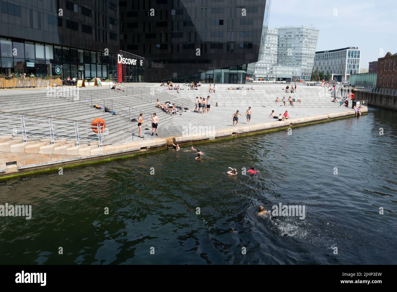 Teenager-Schwimmer kühlen sich am Tag der Rekordtemperatur in Großbritannien ab. Wharf vor Mann Island während der Hitzewelle. Liverpool, Großbritannien. Stockfoto