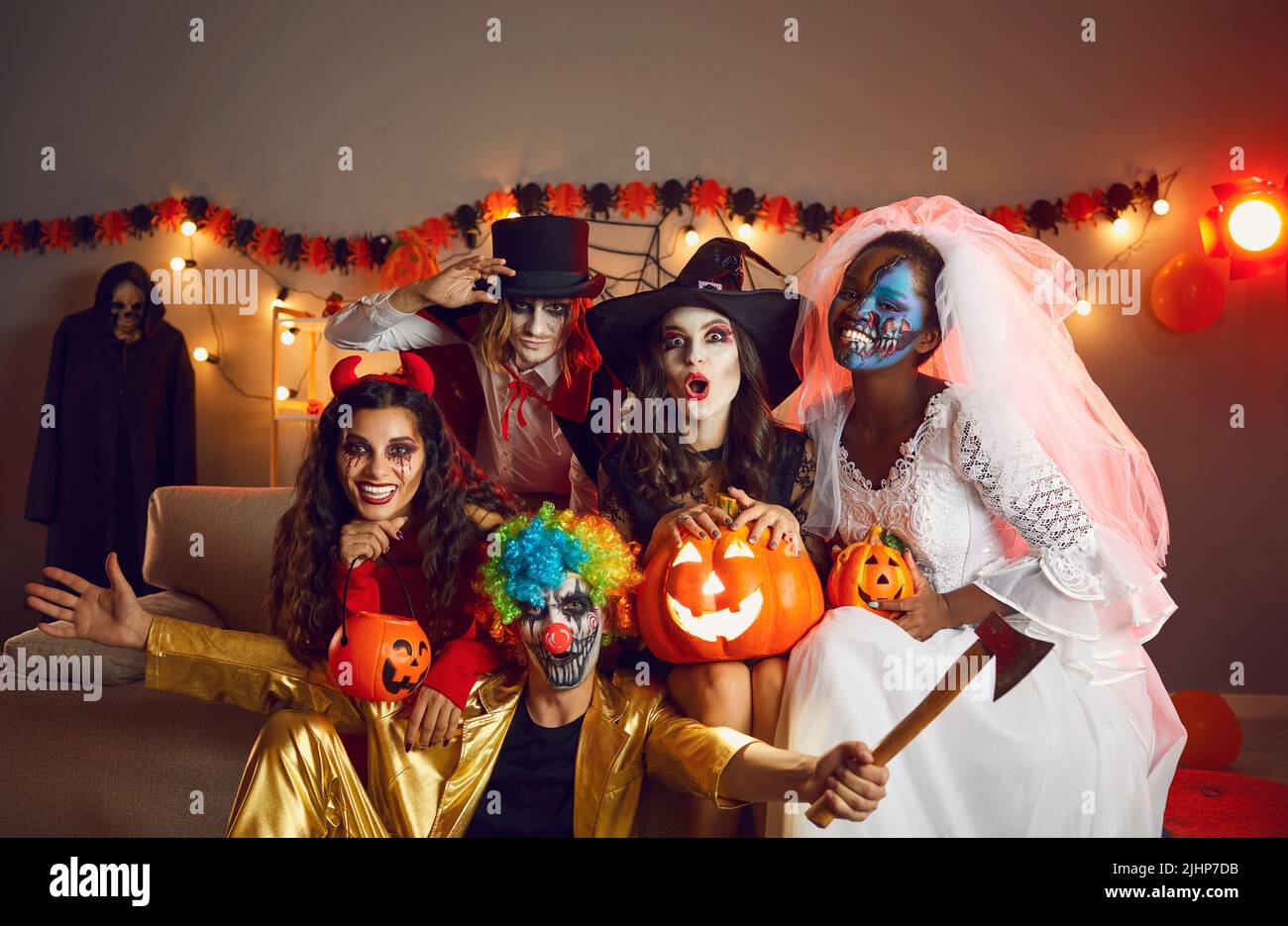 Gruppenfoto von glücklichen erwachsenen Freunden, die als gruselige Monster auf der Halloween-Party gekleidet sind Stockfoto