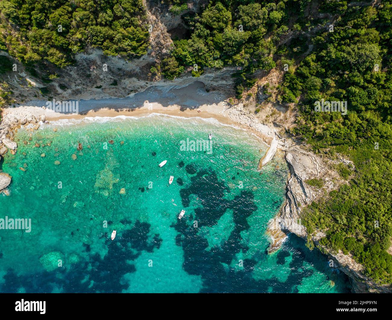 Luftaufnahme des Kolias Strandes auf der Insel Korfu. Griechenland. Klippen mit Blick auf den Strand und ein unberührtes grünes und blaues Meer. Festfahrte Boote Stockfoto