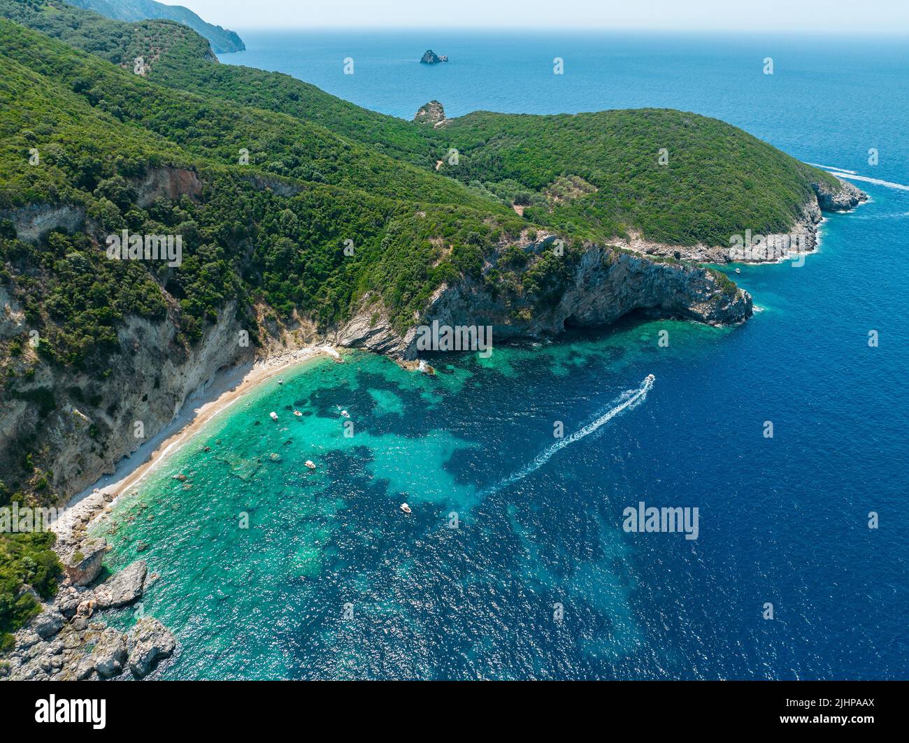 Luftaufnahme des Kolias Strandes auf der Insel Korfu. Griechenland. Klippen mit Blick auf den Strand und ein unberührtes grünes und blaues Meer. Festfahrte Boote Stockfoto