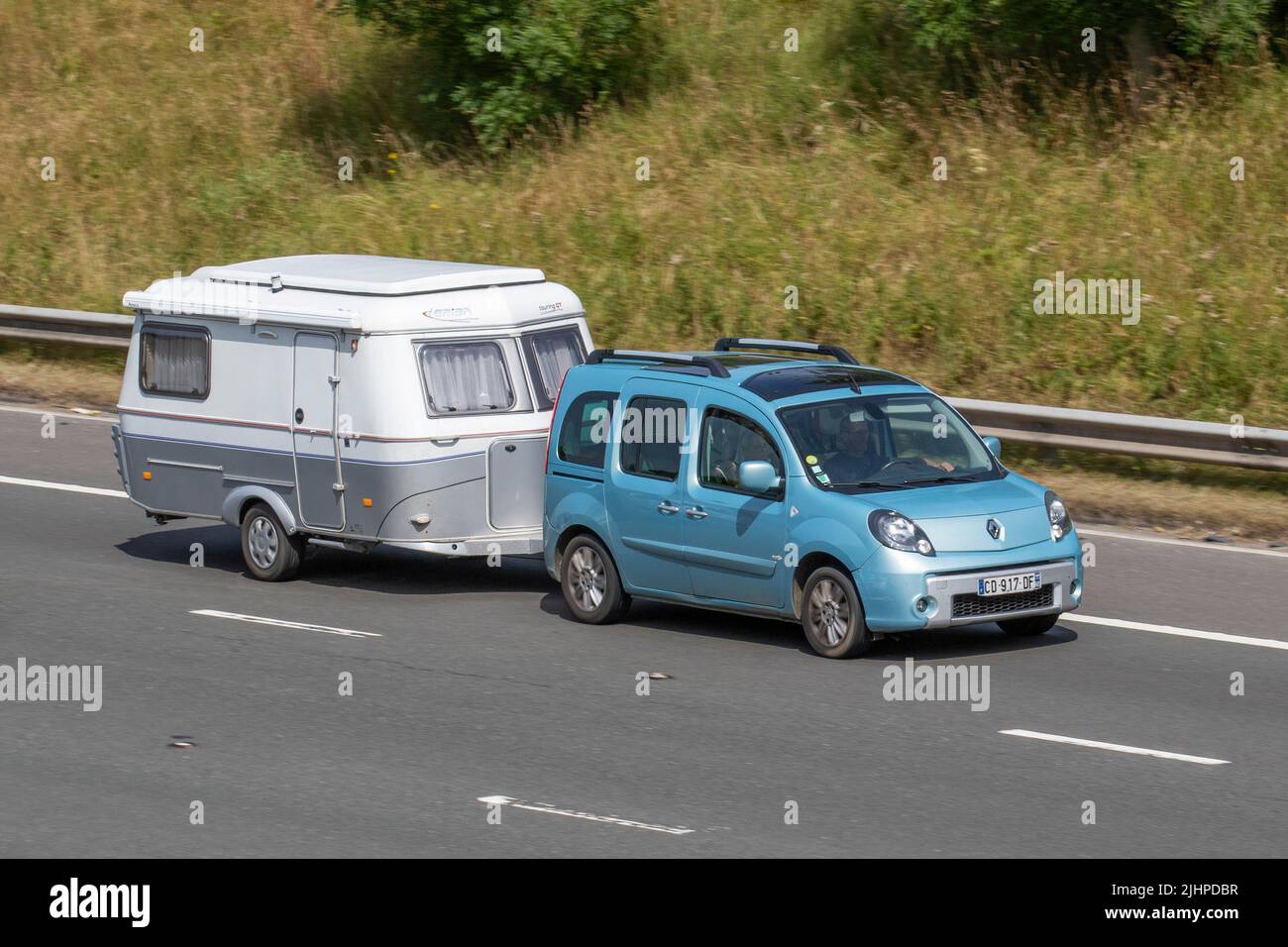 Renault Kangoo, französische Touristen, die einen ERIBA-GT-Wohnwagen schleppen; unterwegs auf der Autobahn M6, Manchester, Großbritannien Stockfoto