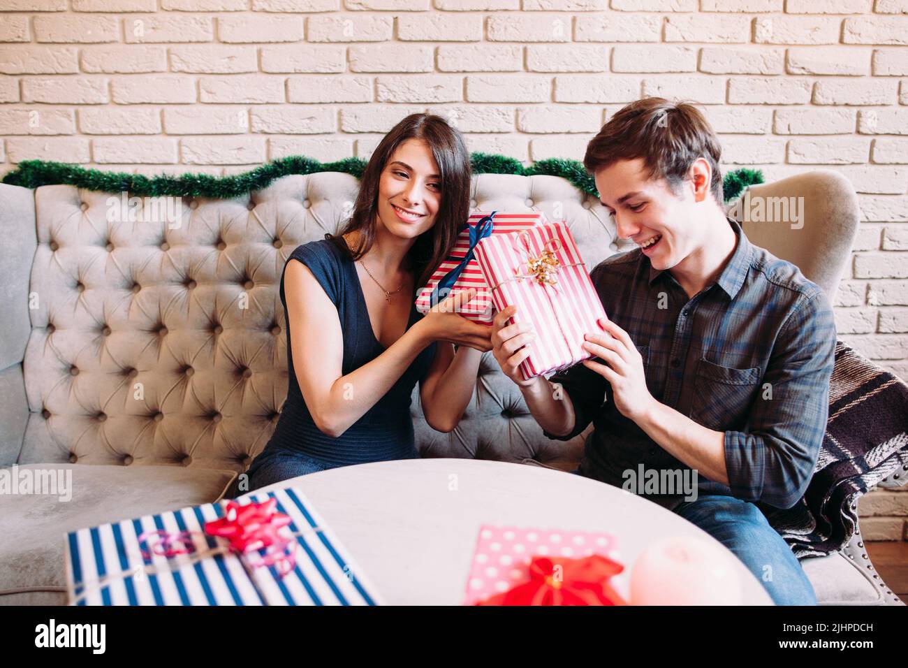 Lächelnder Mann und Frau raten Geschenke, freier Raum Stockfoto