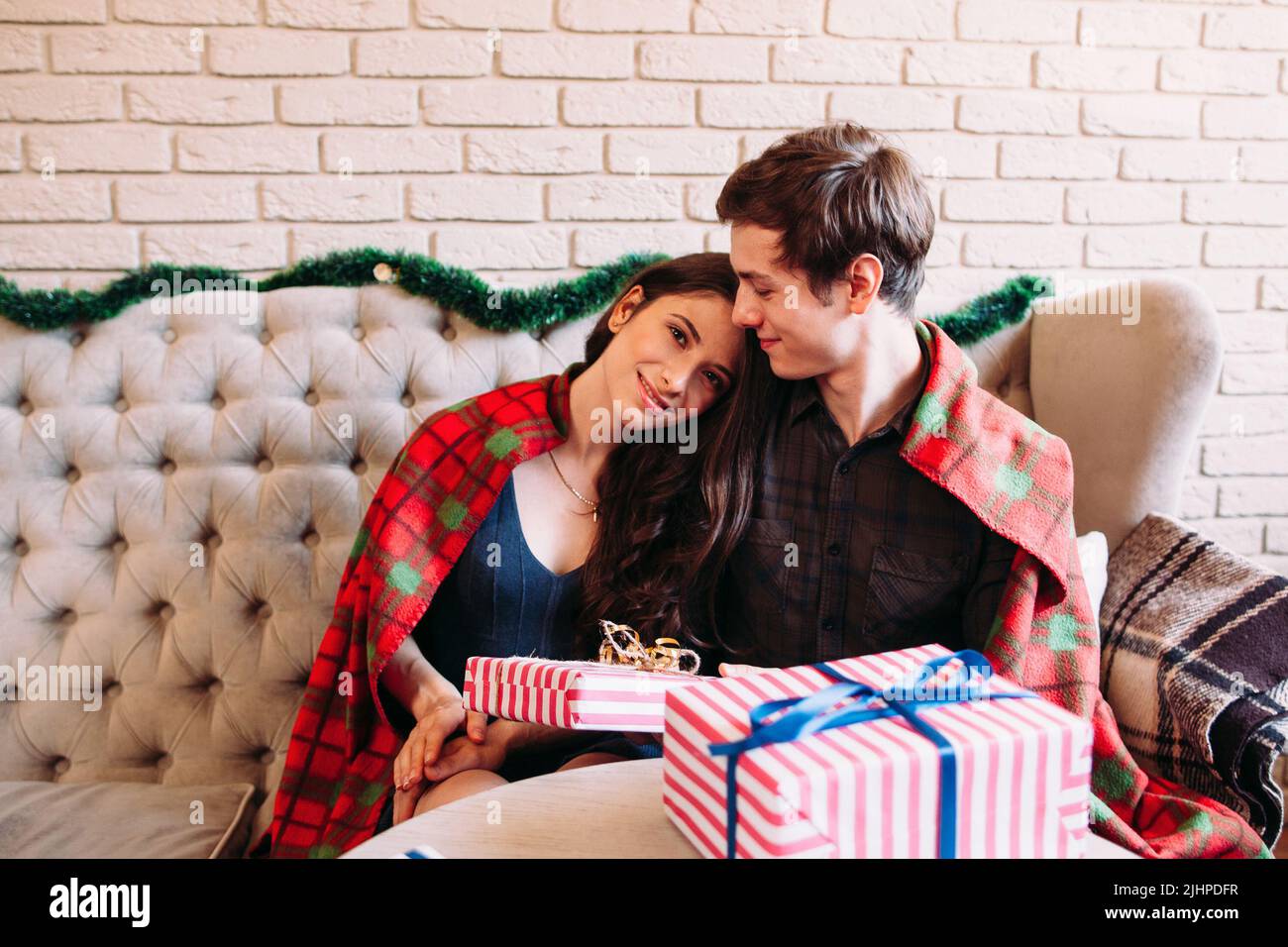 Glückliches Paar, das sich in der Nähe von Weihnachtsgeschenken ausruhen kann Stockfoto