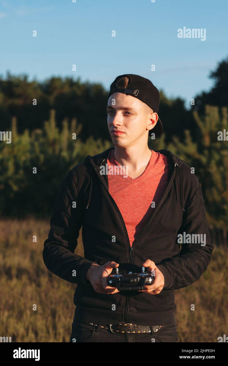 Junger Mann, der mit rc-Sender im Freien steht Stockfoto