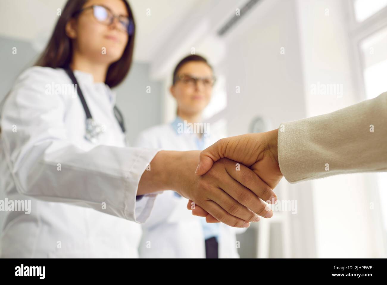 Handschlag Frau Arzt und Patient symbolisieren Rettung Leben von kranken im Krankenhaus Stockfoto