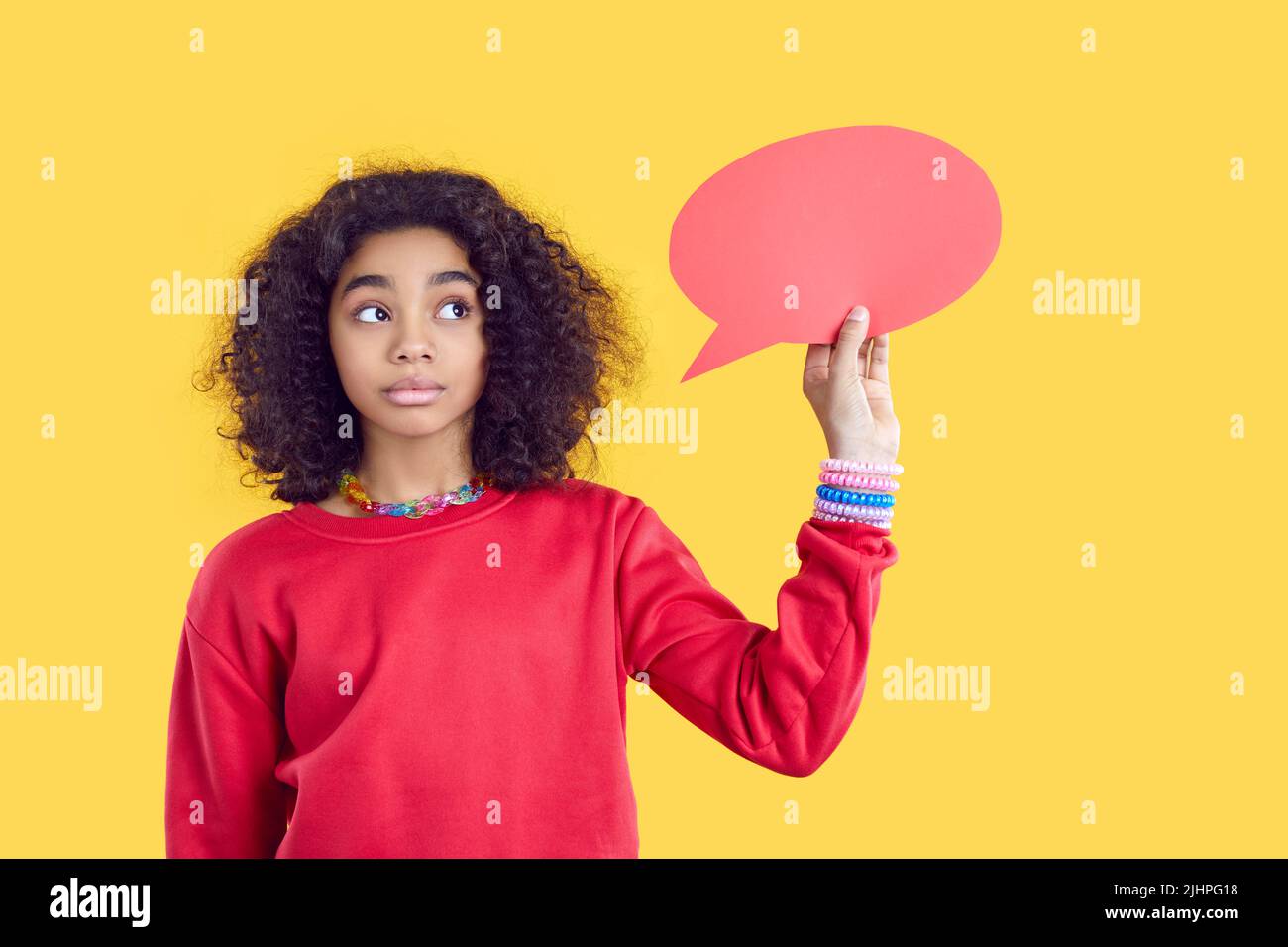 Papier leere Sprechblase in den Händen der nachdenklichen afroamerikanischen Teenager-Mädchen auf gelbem Hintergrund. Stockfoto