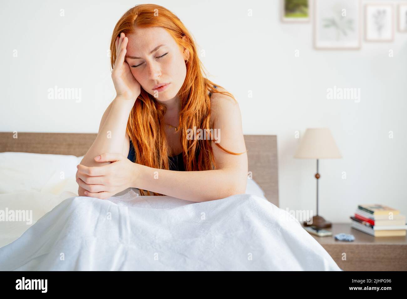 Müde Frau, die wach im Bett liegt, leiden unter Schlaflosigkeit-Kopfschmerzen Stockfoto