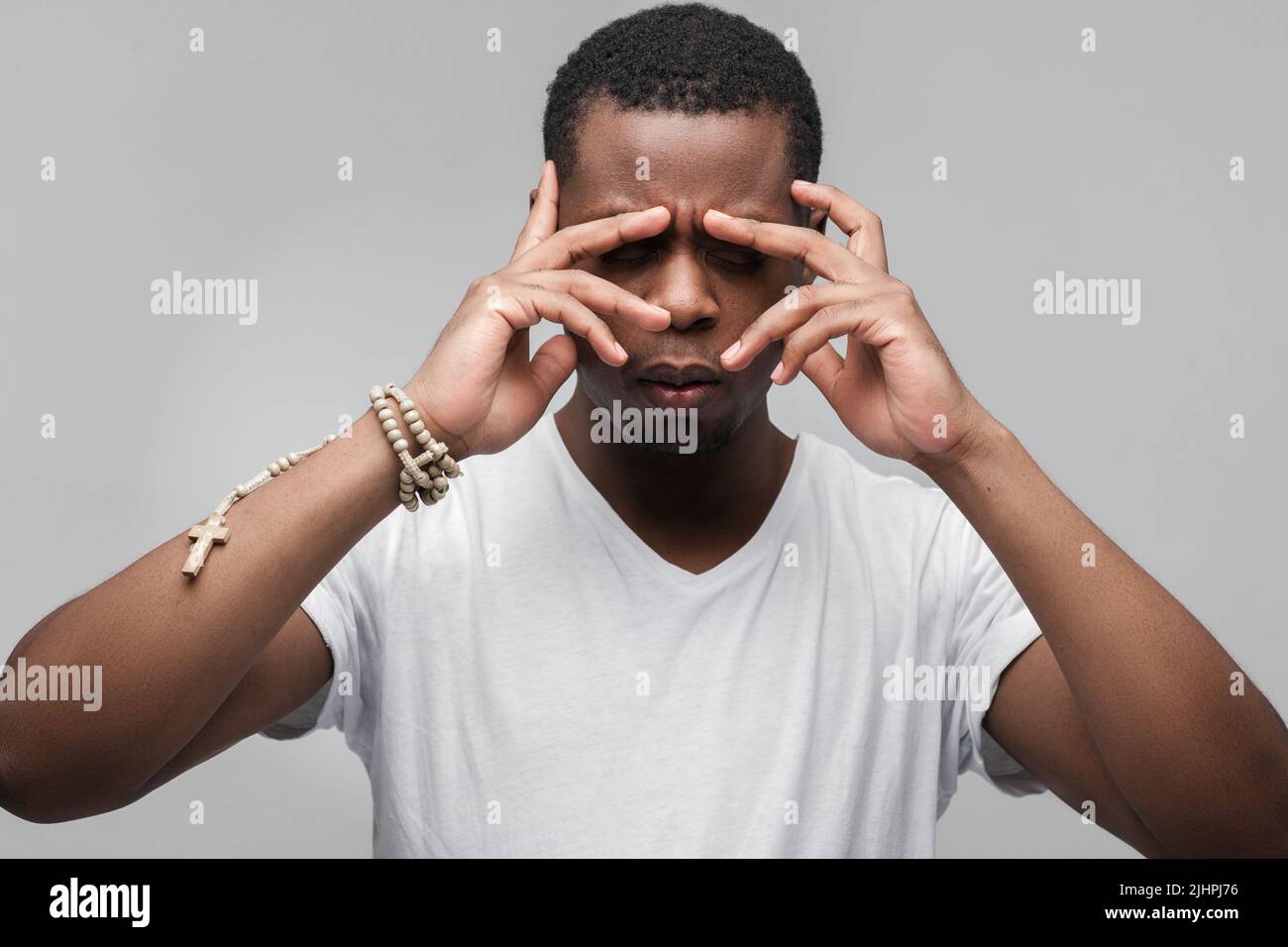 Hochkonzentrierter afroamerikanischer Kerl, der hart denkt Stockfoto