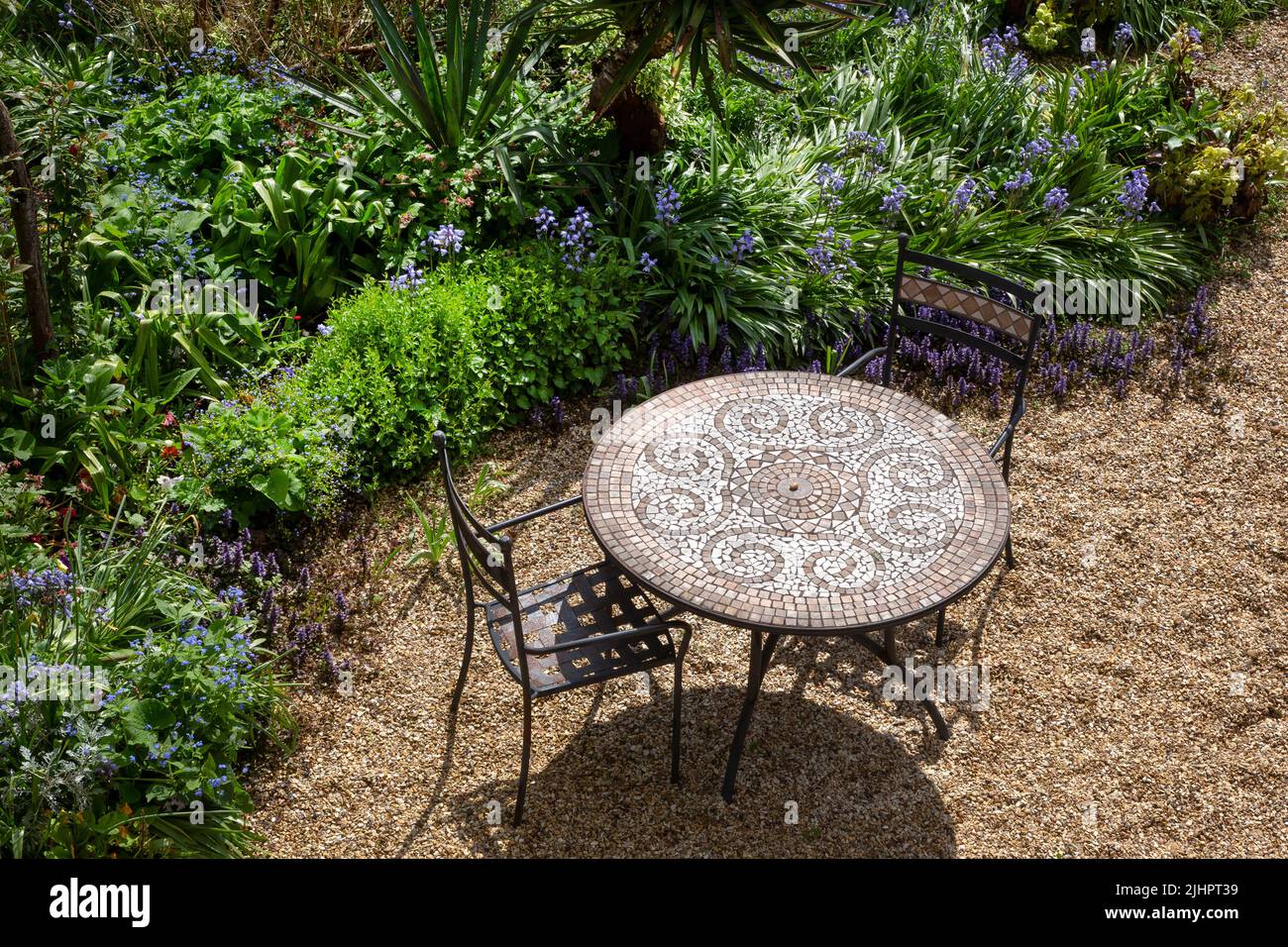 Metalltisch und Stühle im englischen Sommergarten, England Stockfoto