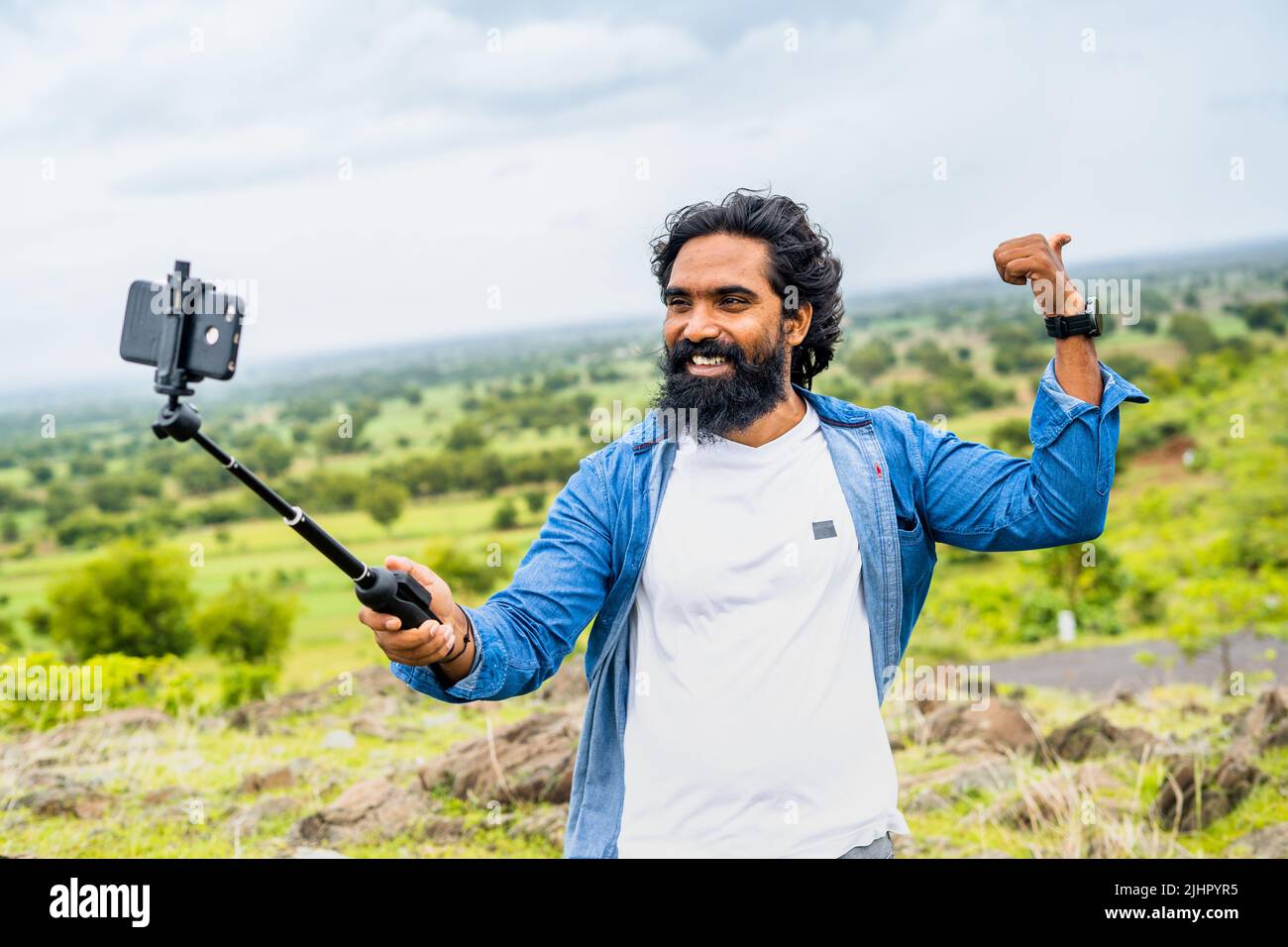 Glücklich lächelnder Reise-Vlogger auf dem Berg Aufnahme Video auf dem Handy für soical Medien - Konzept der Influencer und Content Creator und Stockfoto