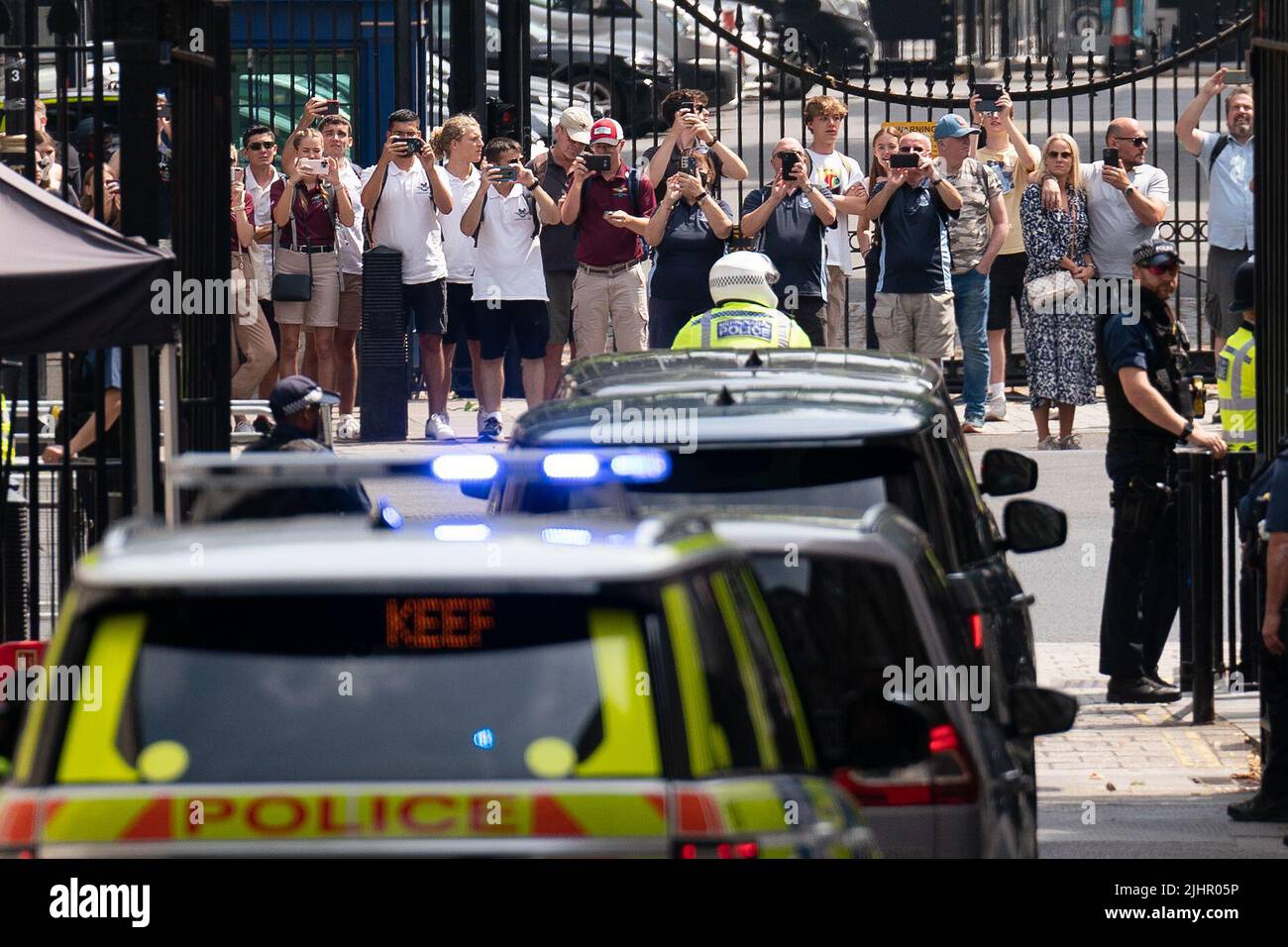 Touristen sehen sich an, wie die Autokolonne von Premierminister Boris Johnson die Downing Street 10, Westminster, London, verlässt, um an seinen letzten geplanten Fragen des Premierministers im Parlament teilzunehmen. Bilddatum: Mittwoch, 20. Juli 2022. Stockfoto
