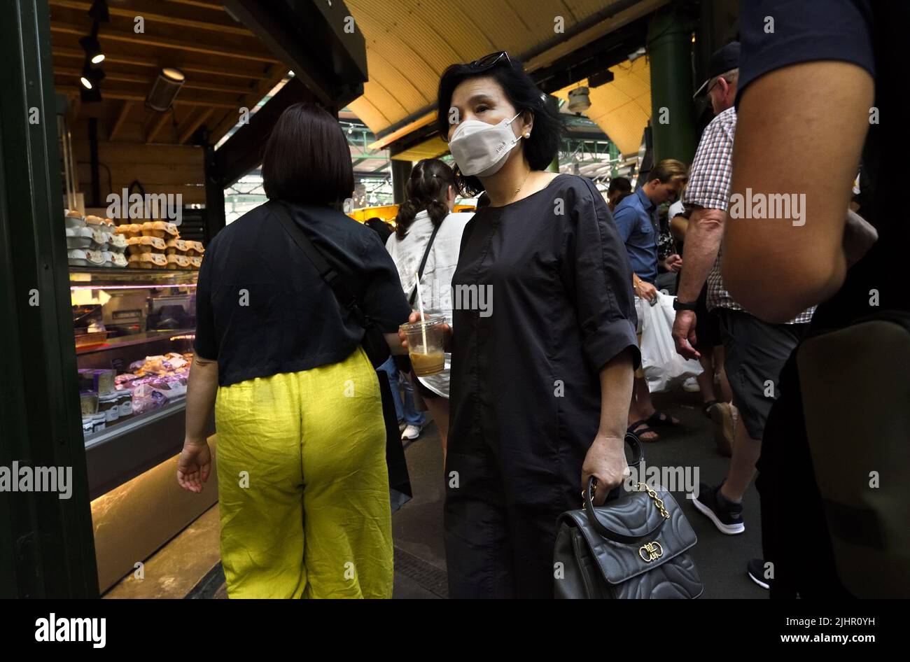 London, England, Großbritannien. Borough Market, Southwark. Asiatische Frau trägt eine Gesichtsmask. Juli 2022 Stockfoto