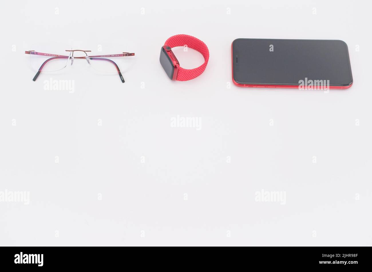Apple iphone und Apple Watch Produkt rot auf einem weißen Schreibtisch mit Platz für Text Stockfoto