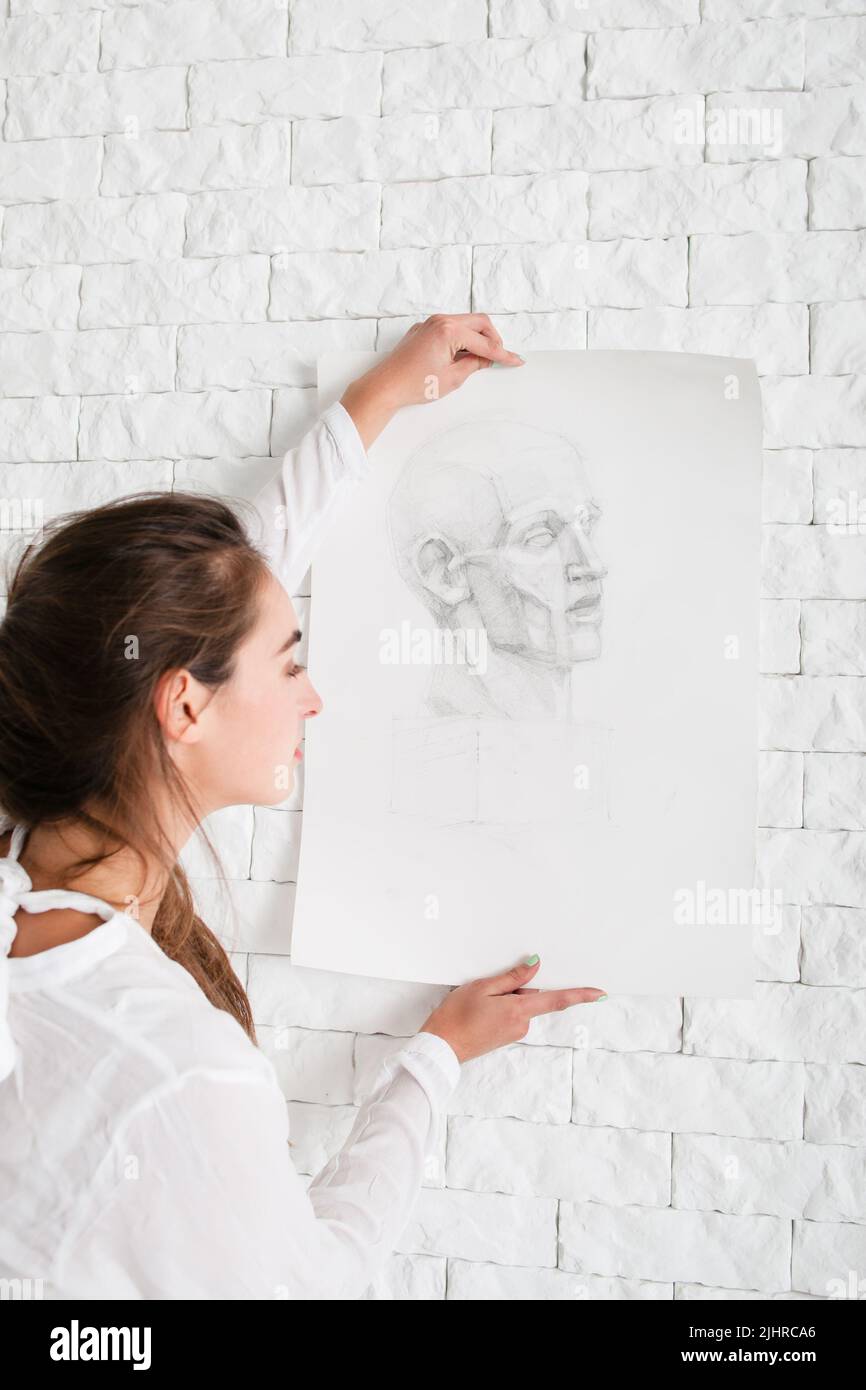 Die Künstlerin hängt ihr Bleistiftportrait an die Wand Stockfoto