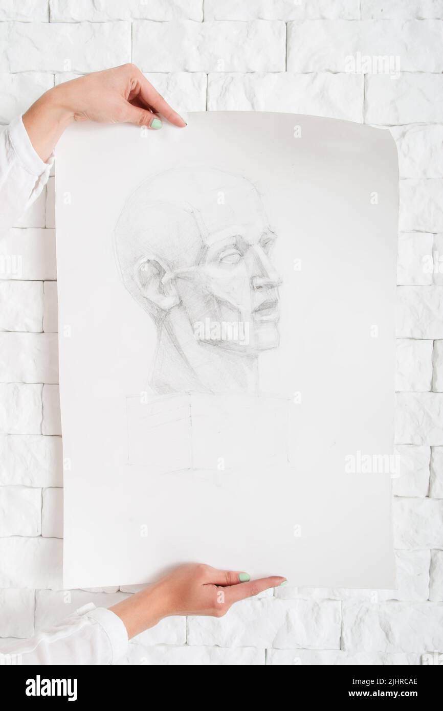 Bleistiftportrait in Künstlerhand gegen Wand Stockfoto