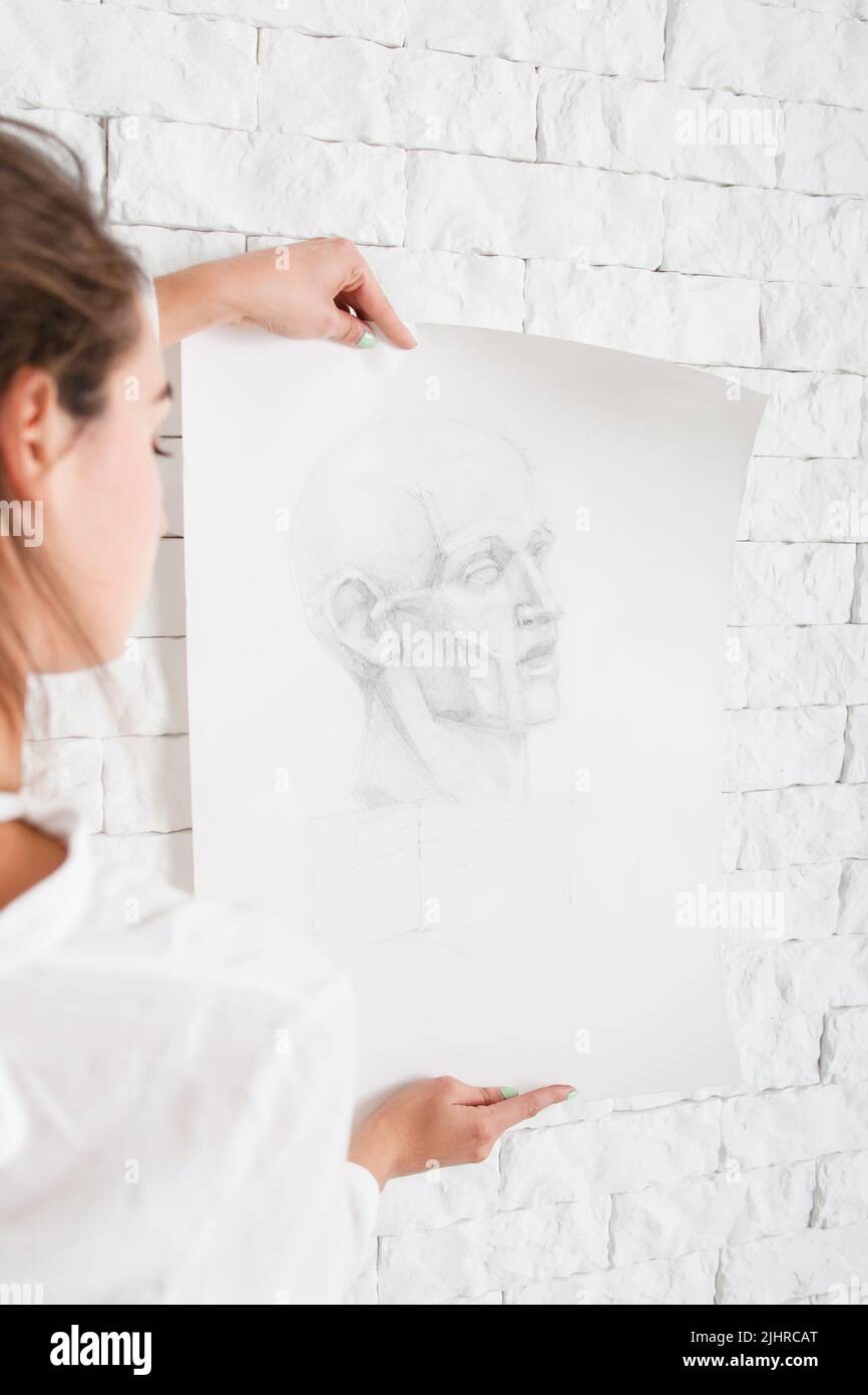 Künstler hält Bleistiftportrait an der Wand Stockfoto
