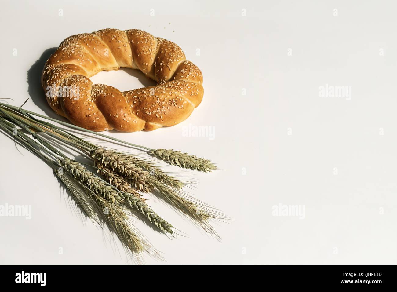 Frischer Brotlaib auf weißem Tisch. Gebackenes Brot und Ähren von Weizen Stillleben. Stockfoto