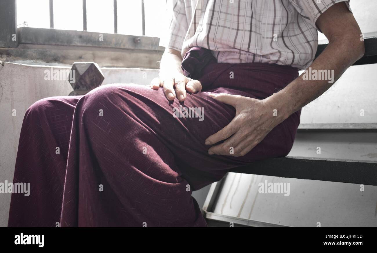 Oberschenkelschmerzen bei einem älteren männlichen Patienten in Asien. Konzept der Ischias oder Ischiasnerv Schmerzen. Stockfoto