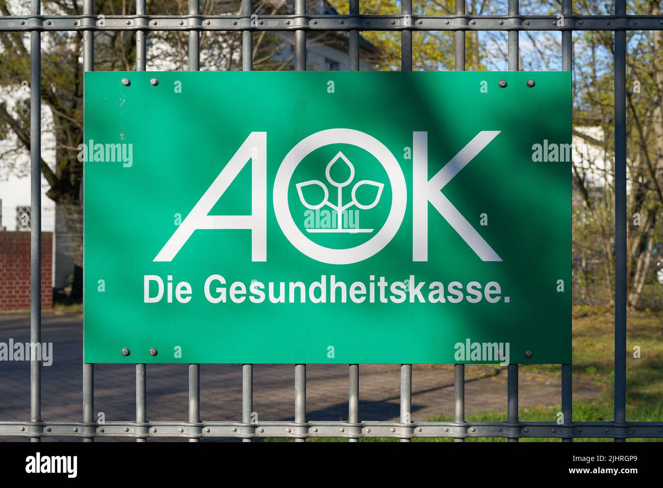 Unterschreiben Sie auf einem Zaun einer Niederlassung der Krankenkasse AOK in Wittenberg in Deutschland Stockfoto