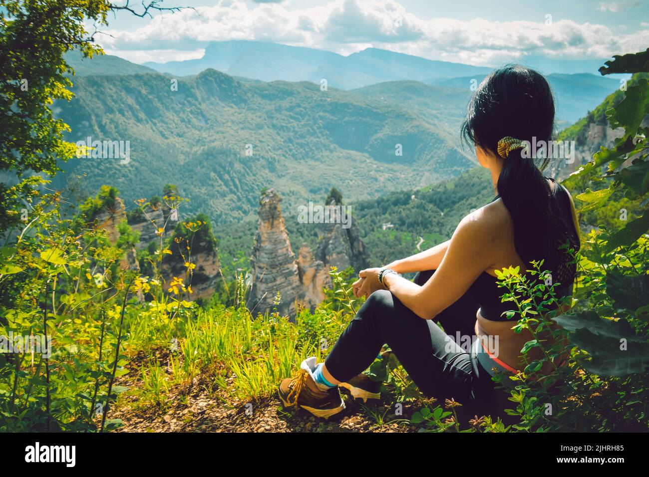 Rückansicht Sportlicher kaukasischer Sit Relax Genießen Sie das Panorama der malerischen grünen Berge in Georgien, nachdem der Wanderweg den Gipfel im Freien erreicht hat Stockfoto