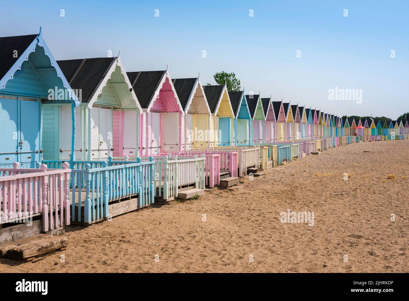 Essex UK Beach, Blick im Sommer auf bunte Strandhütten am Sandstrand in West Mersea, Mersea Island, Essex, England, Großbritannien Stockfoto