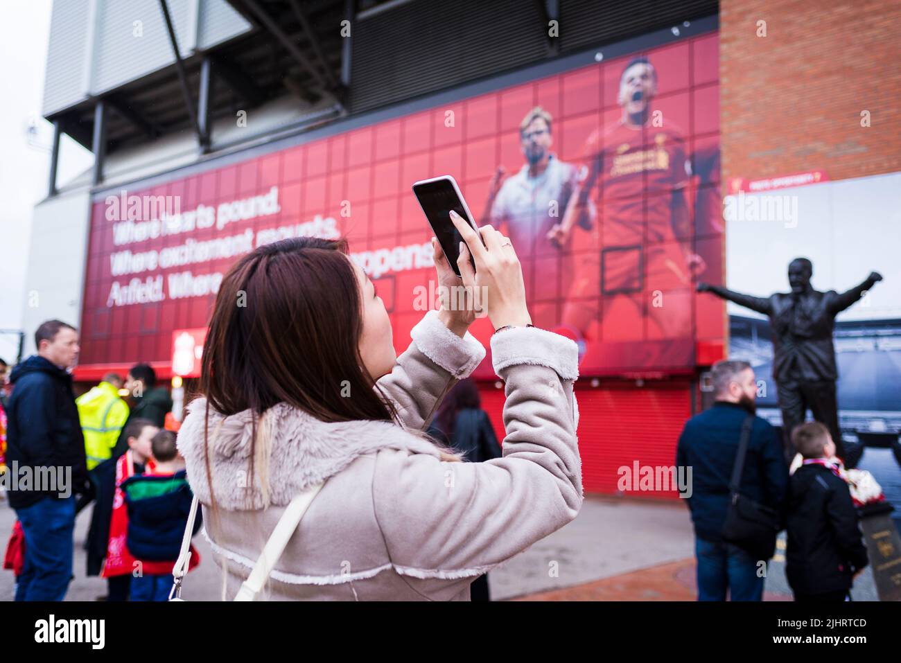 Fans des FC Liverpool neben der Bill Shankly-Statue im Anfield Stadium. Anfield, Liverpool, Merseyside, Lancashire, England, Vereinigtes Königreich Stockfoto