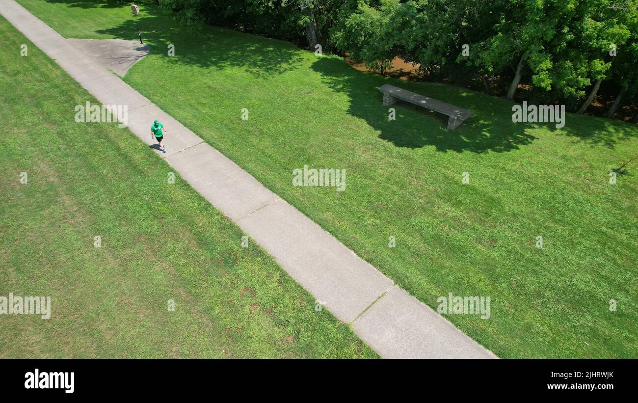 Eine Luftaufnahme eines Parks mit einem Mann, der auf einer Straße läuft Stockfoto