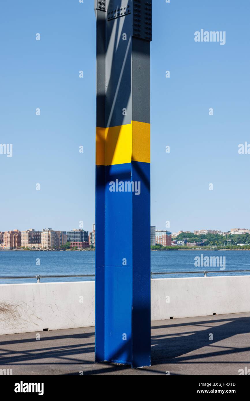 Eine vertikale Aufnahme einer Metallsäule gegen eine Skyline der Stadt Stockfoto