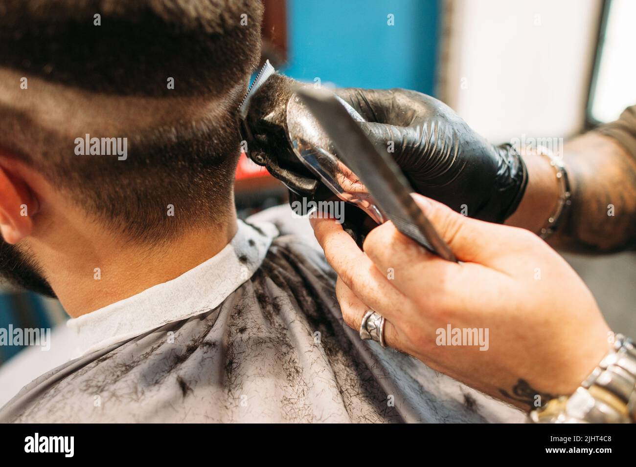 Ein Mann, der in der Nähe des Friseursalons einen lockigen Haarschnitt macht Stockfoto