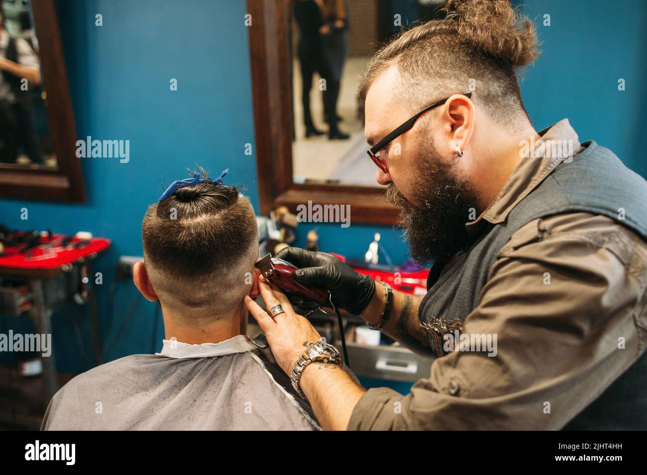 Stylist, der den männlichen Kopf im Friseurladen rasieren kann Stockfoto