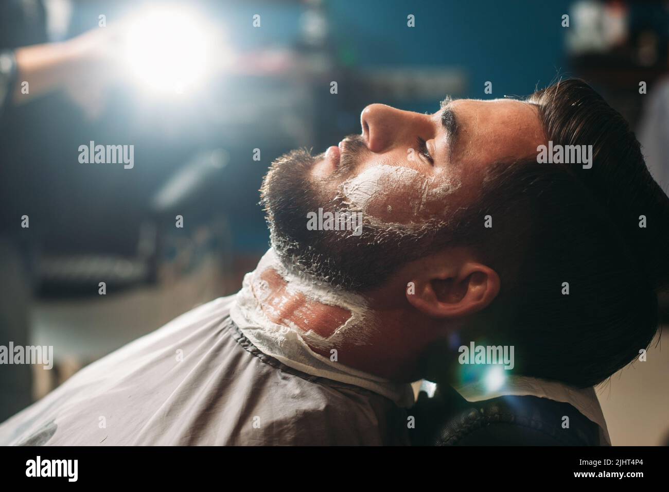 Profil eines jungen Mannes, der im Friseurladen sitzt Stockfoto