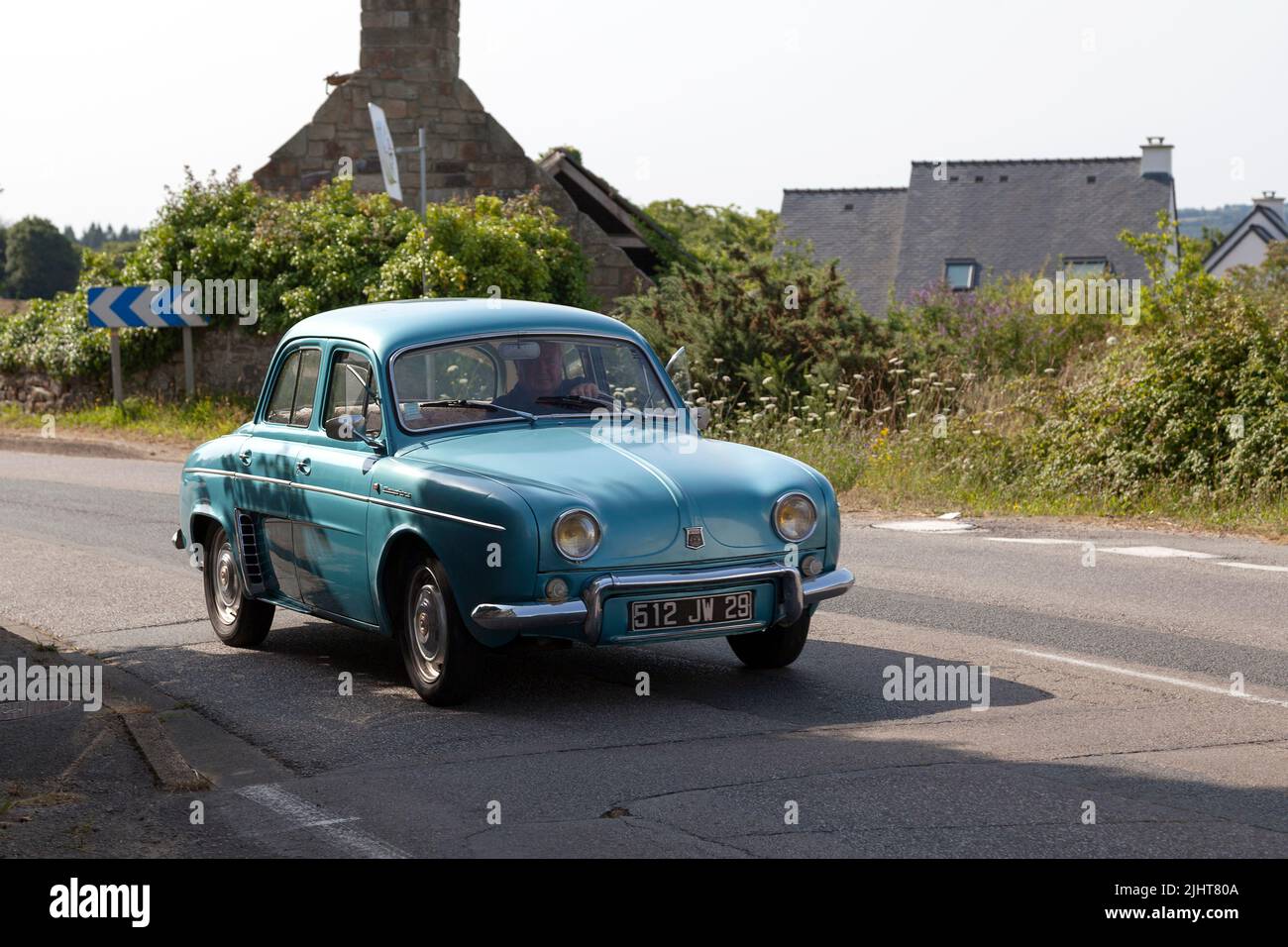 Kerlaz, Frankreich - Juli 17 2022: Pensionierter Mann, der in einem blauen Renault Dauphine fährt. Stockfoto