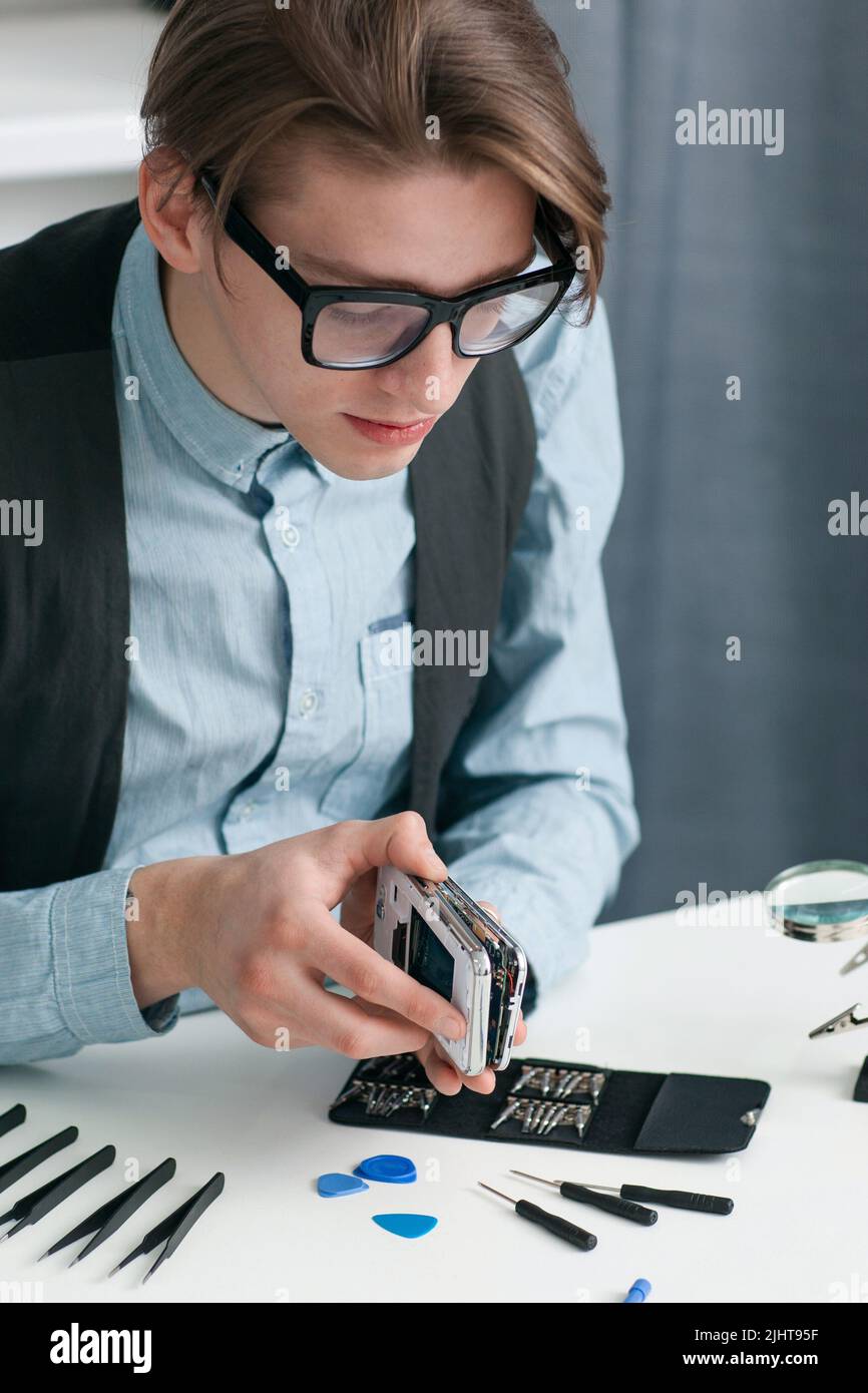 Mann zerlegt Smartphone in der Werkstatt Stockfoto