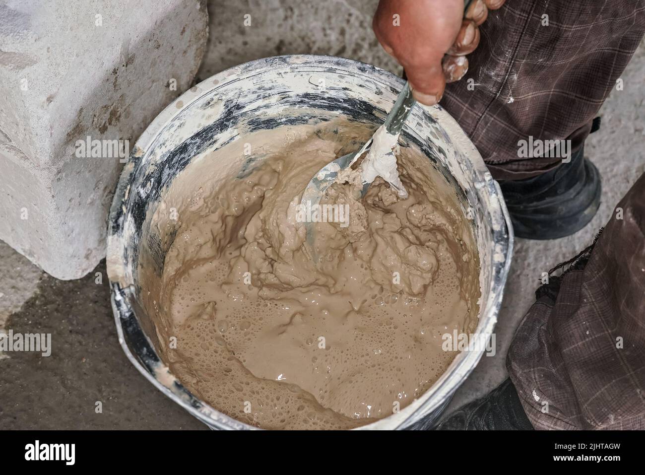 Nasse Mörserzementpaste in Eimer gemischt, Nahaufnahme Detail von oben Stockfoto