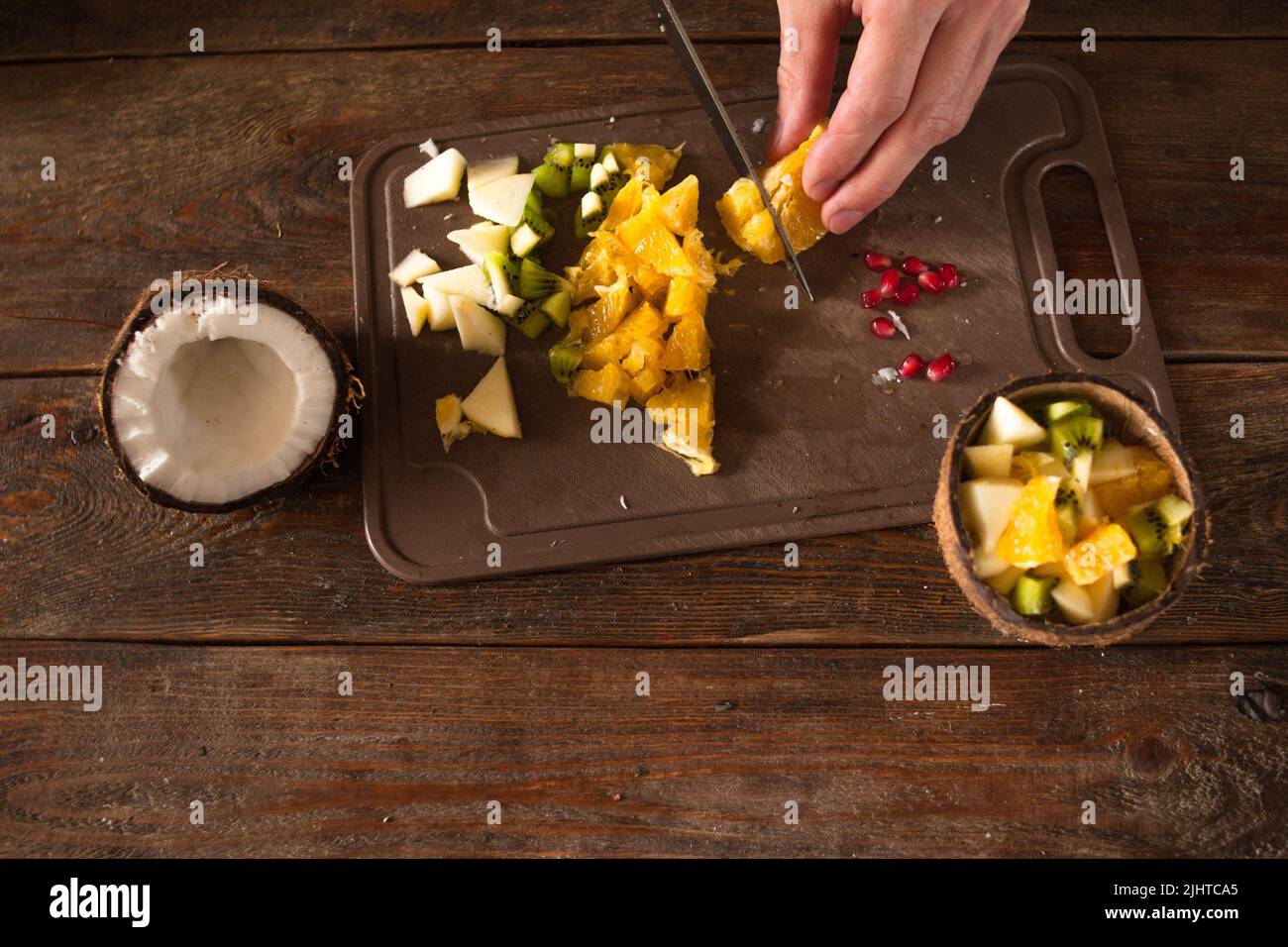 Vorbereitung von Obstsalat in Kokosnussschale Stockfoto