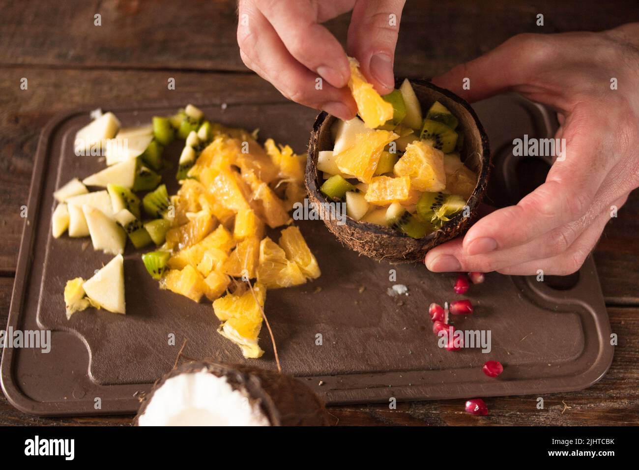 Vorbereitung von Obstsalat in Kokosnussschale Stockfoto