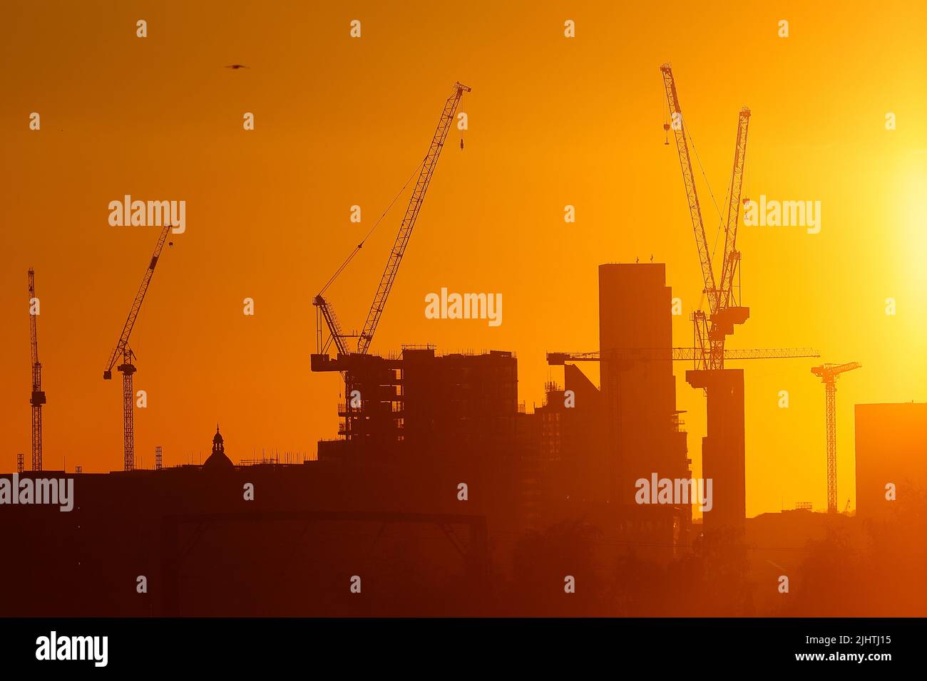 Turmdrehkrane im Zentrum von Leeds, West Yorkshire, Großbritannien, wurden gegen einen Sonnenaufgang silhouettiert Stockfoto