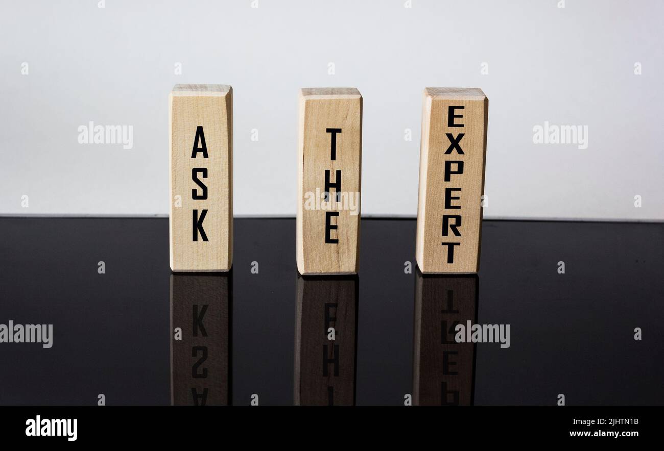 FRAGEN SIE DEN EXPERTEN geschrieben auf Holzklötze und schwarz-weißen Hintergrund mit Reflexion Stockfoto