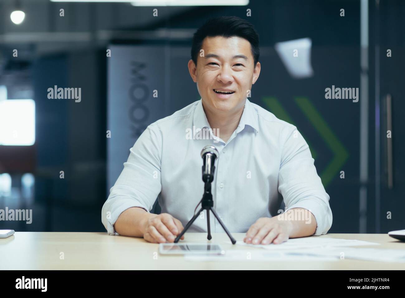 Porträt des erfolgreichen Business Trainer Coach, Mann lächelnd und Blick auf die Kamera, Geschäftsmann arbeiten im Büro, mit professionellen Mikrofon für Online-Radio und Podcast-Aufzeichnung Stockfoto