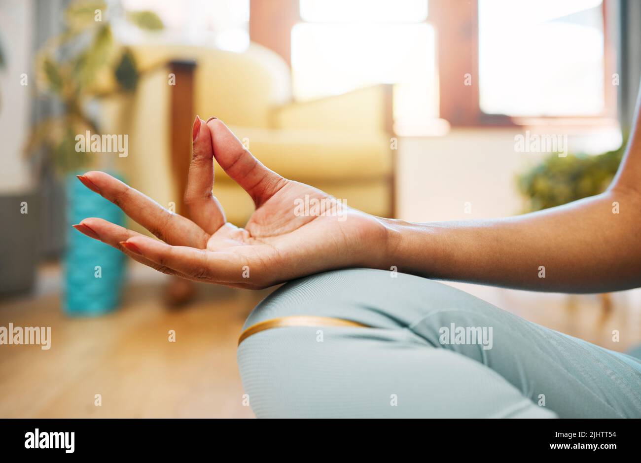 Die Ruhe des Geistes und des Körpers zu bewahren. Nahaufnahme einer unverkennbaren Frau, die zu Hause meditiert. Stockfoto