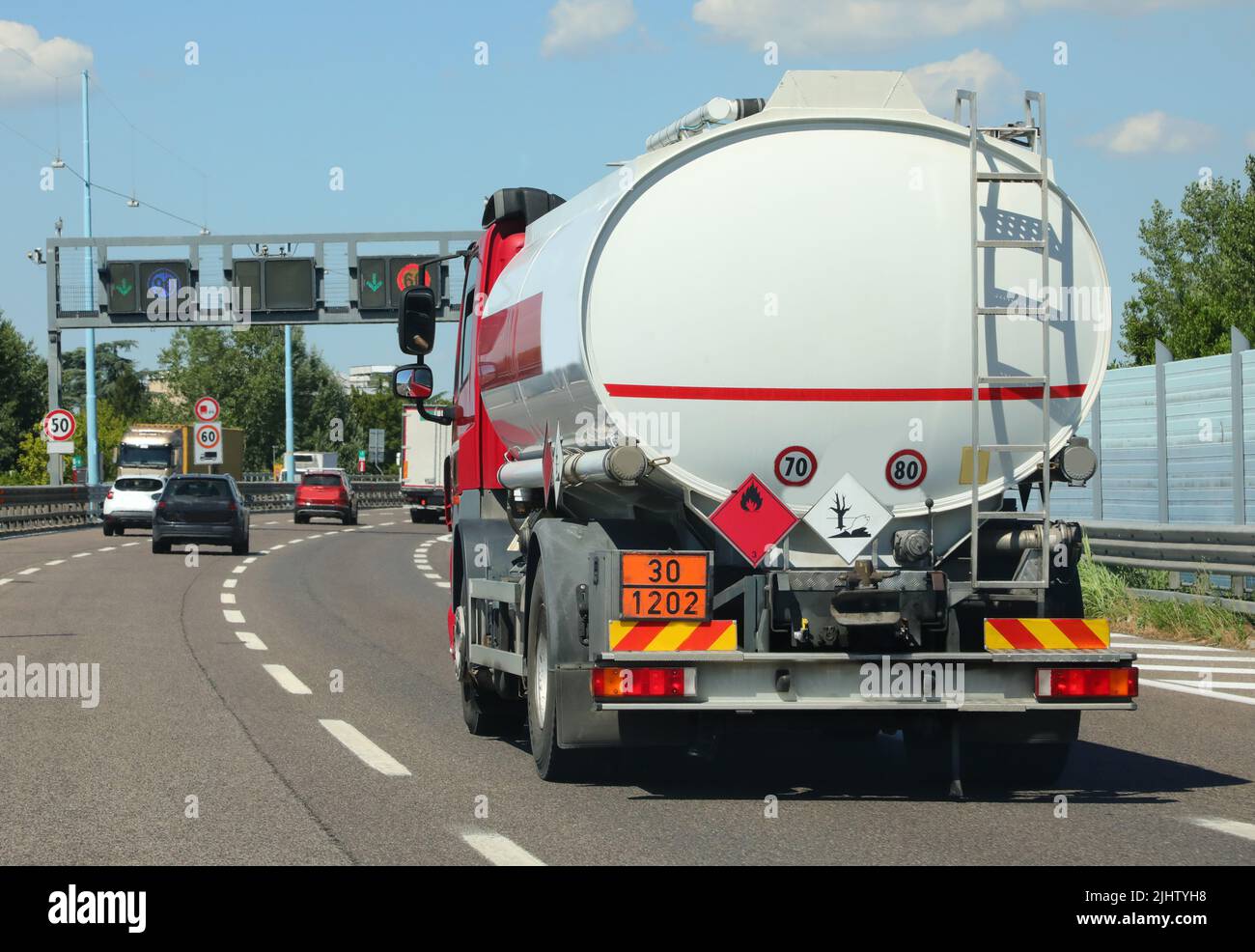 Tankwagen für den Transport von brennbaren Materialien läuft schnell auf der Autobahn mit Fahrzeugverkehr Stockfoto