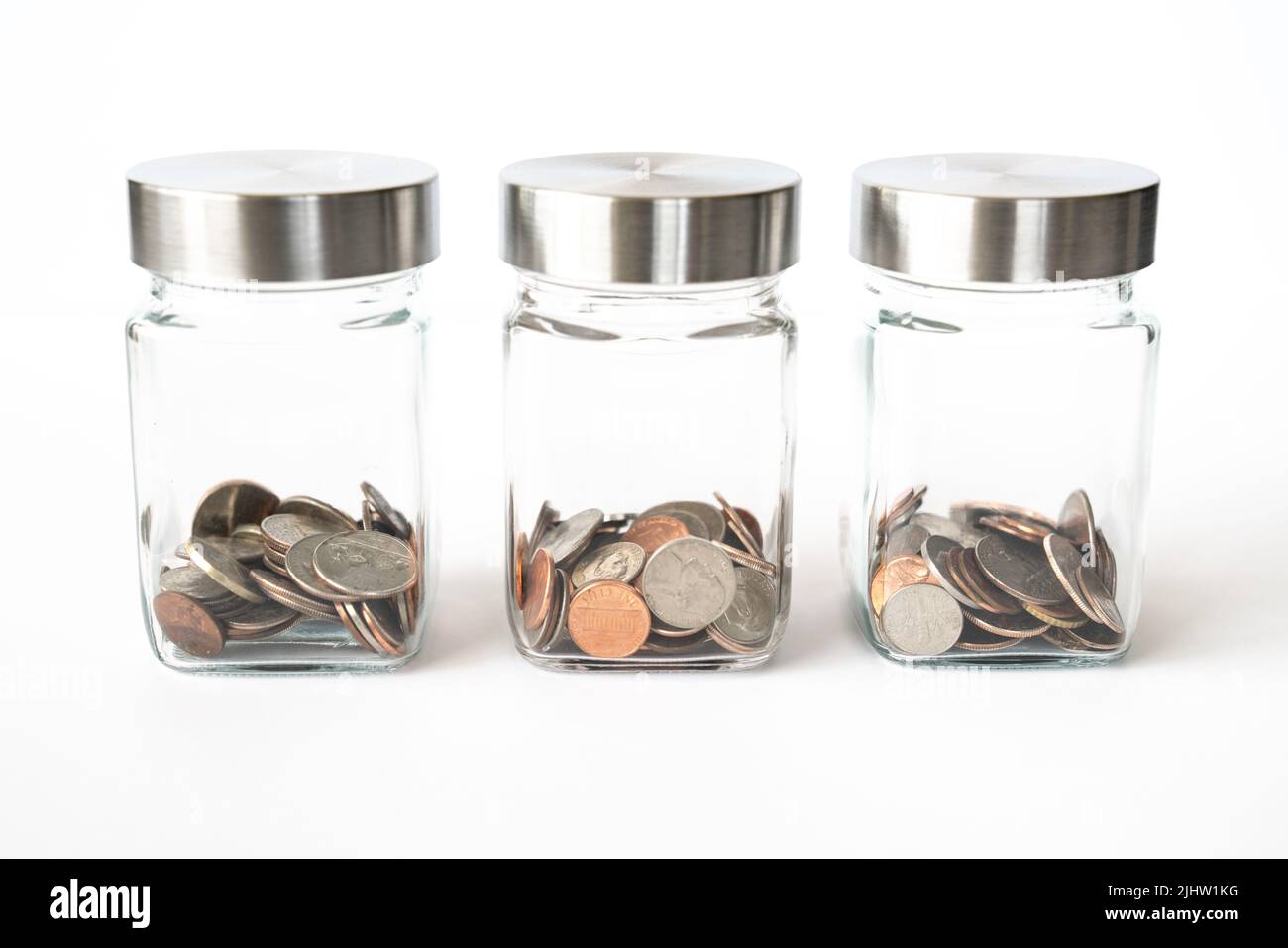 Gläser mit Münzen, die den Sparzielen und dem Budget zugewiesen sind Stockfoto
