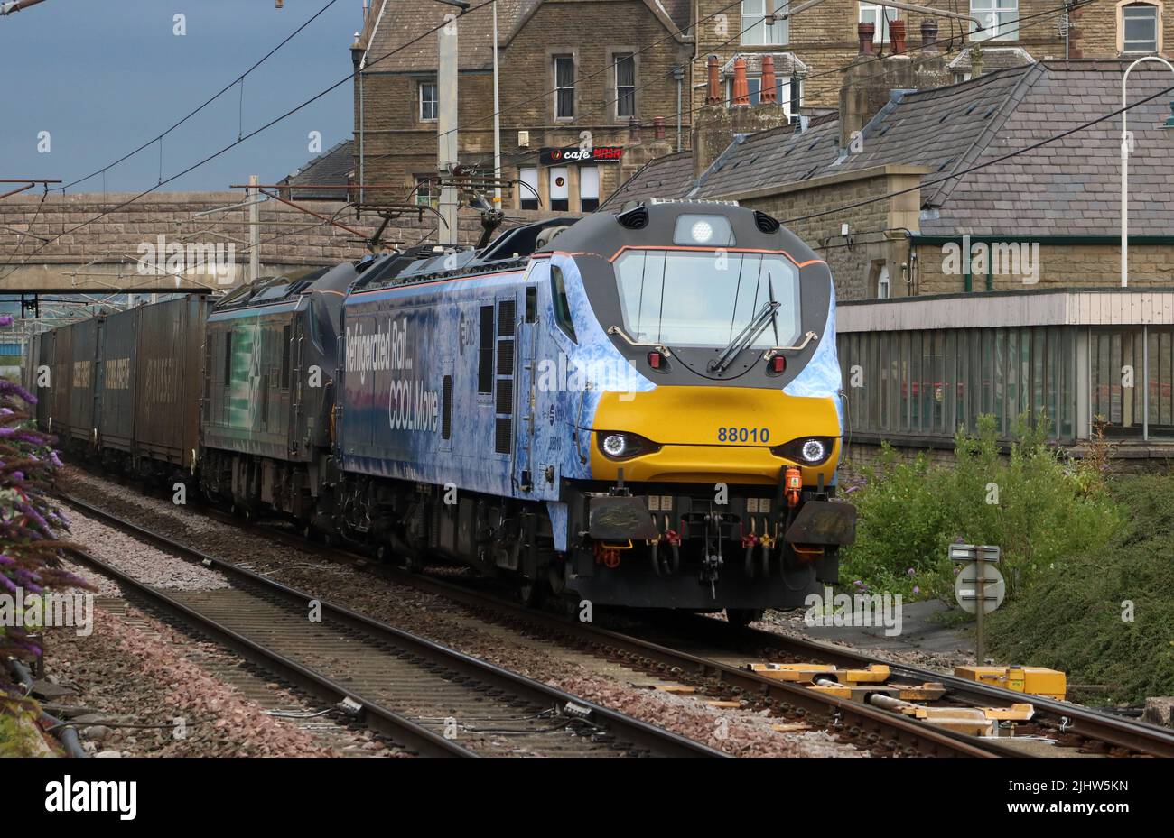 Gekühlte Schiene COOL bewegen neue Lackierung auf 88010 mit 88006 Richtung Süden auf WCML durch Carnforth mit Containerzug am Mittwoch 20. Juli 2022. Stockfoto