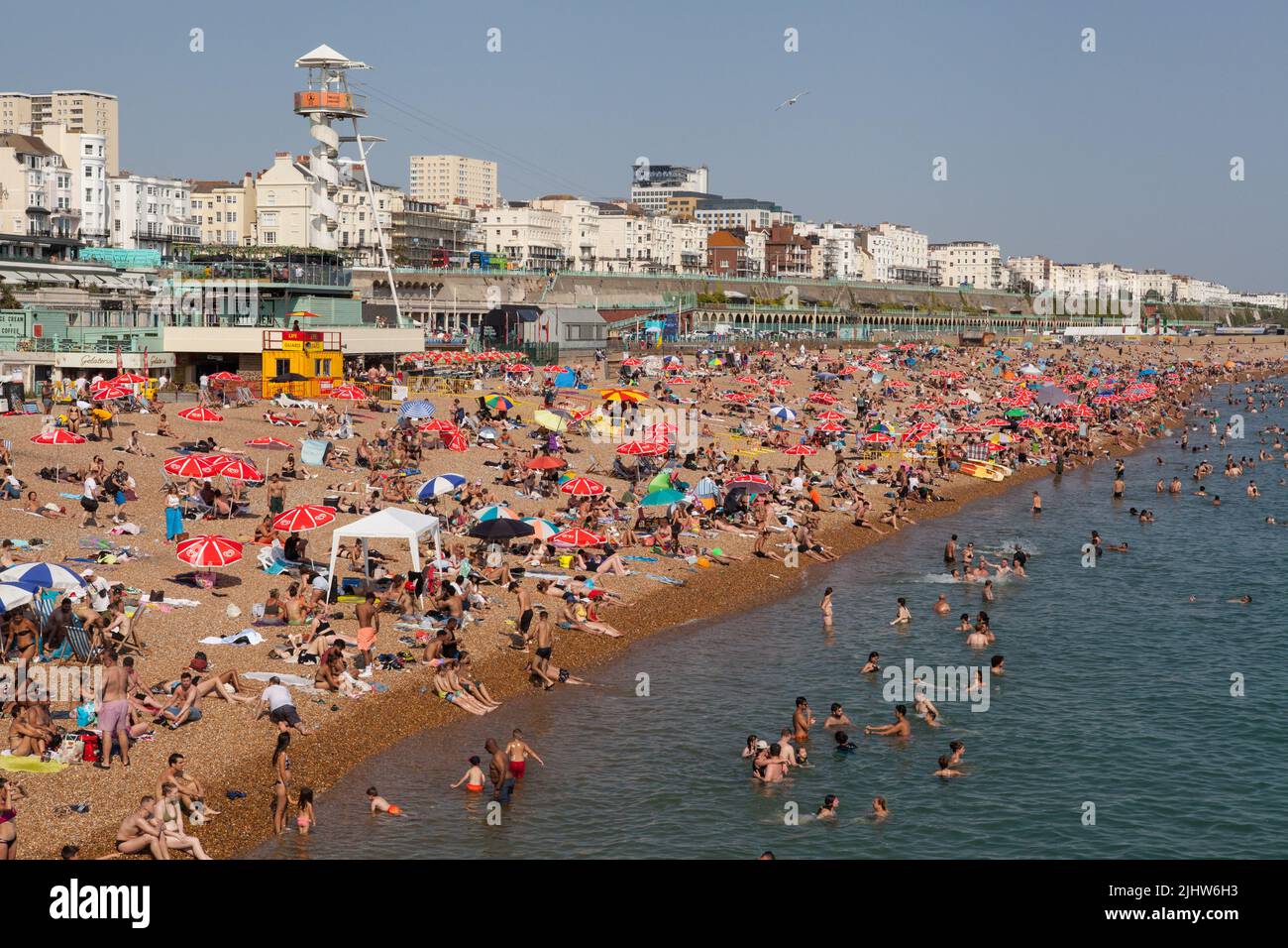 Ein überfüllter Strand im Sommer an der Strandpromenade von Brighton Stockfoto